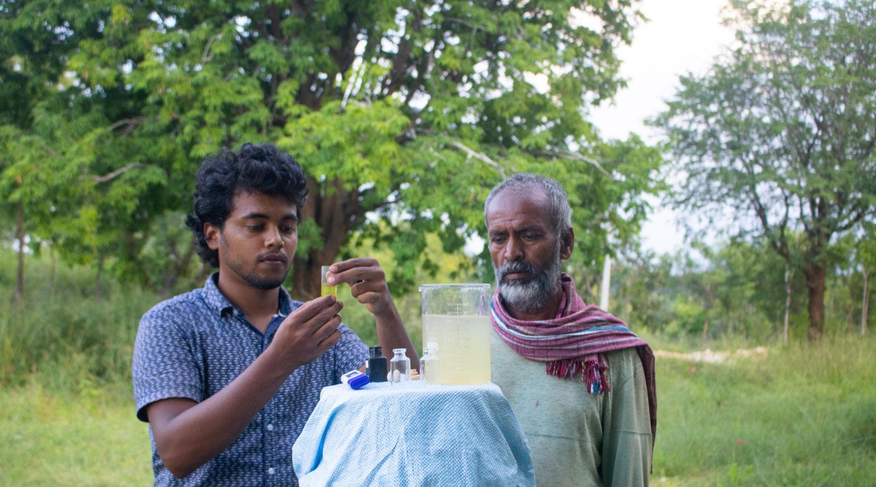 A HasiruAqua farmer standing at the edge of a stocked farm pond